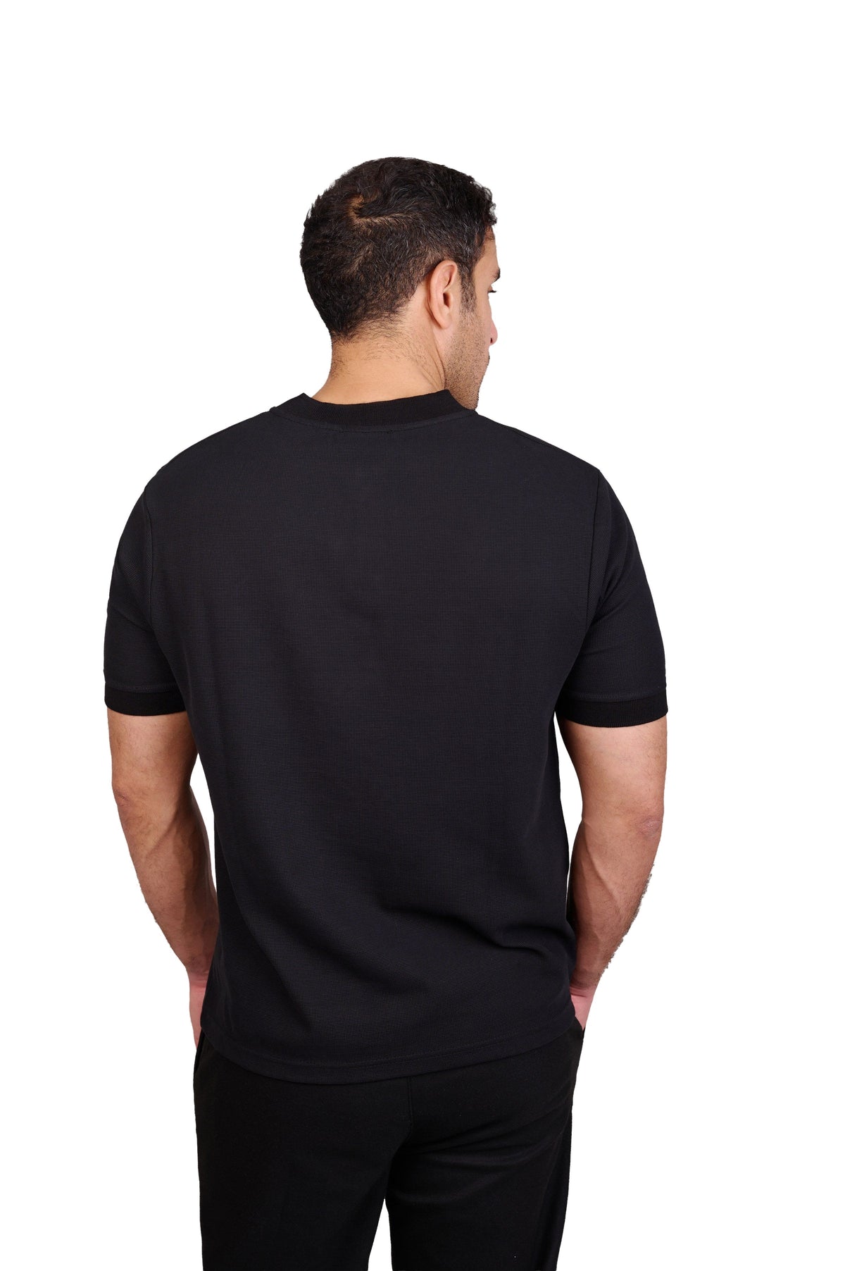 Rflx Reflection Polo, a cotton knit polo with a ribbed mandarin band collar, in black, back view showing the plain body and ribbed band collar